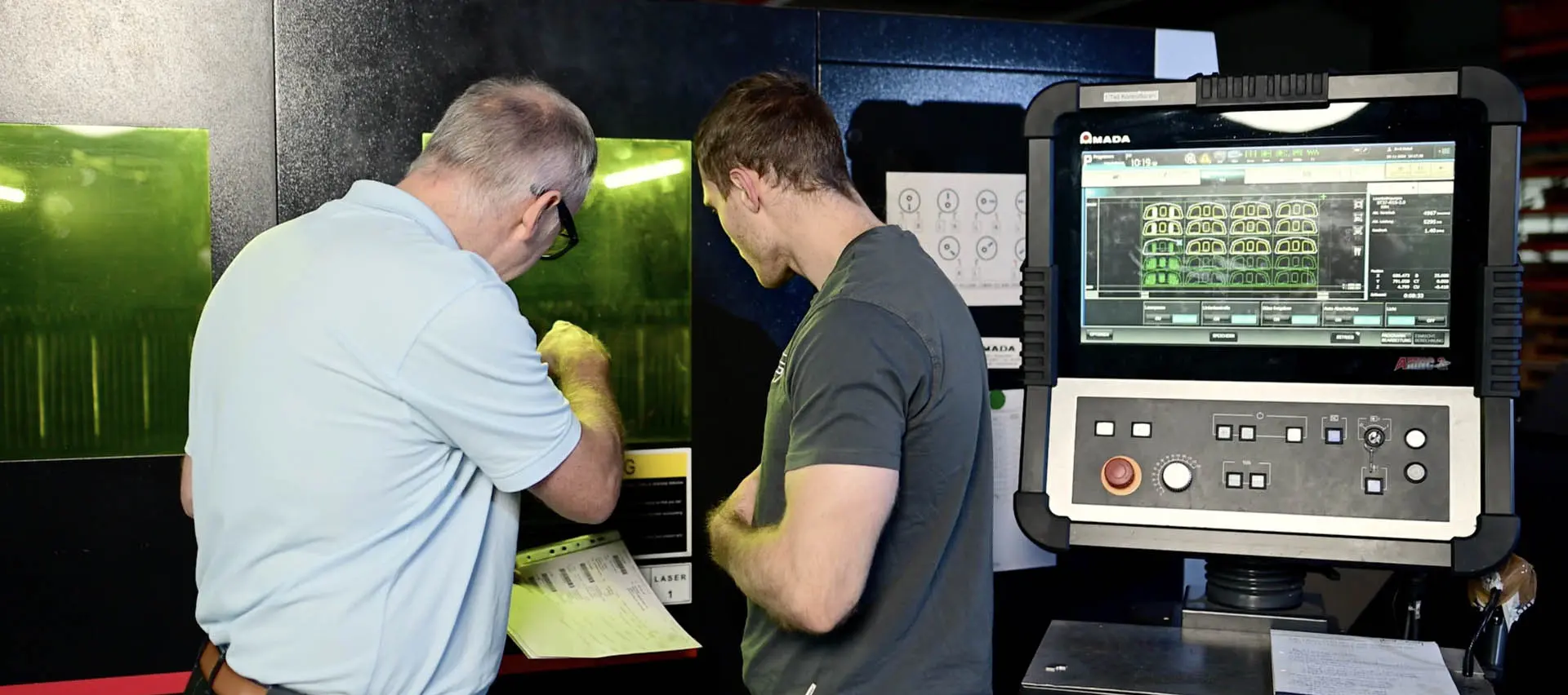 a man looking at a paper in front of a machine